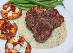 Grilled lamb chop on top of Bearnaise Sauce with a side of sweet potato discs and green beans.