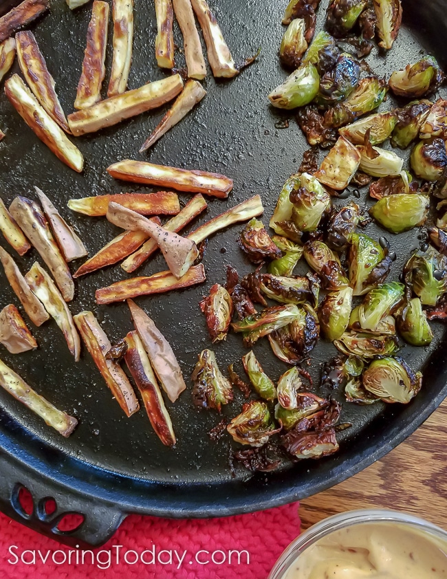 Love using my cast iron pizza pan for roasting vegetables because it browns everything so well. These sweet potatoes and Brussels sprouts are two side dishes done at once! Roasted sweet potato fries and Brussels sprouts on a cast iron pizza pan.